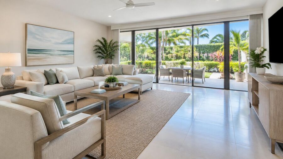 Bright, well-maintained living room in a South Florida rental home, opening onto a sunlit patio.